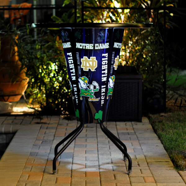 A metal University of Notre Dame pub table with a logo on it.