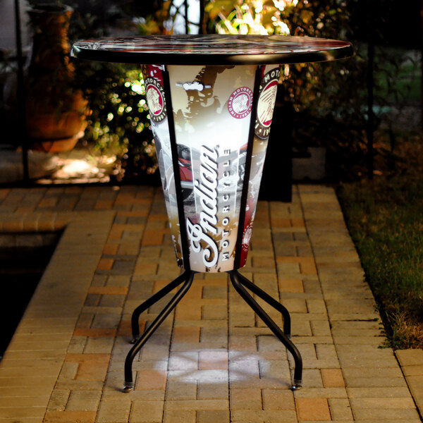 A round bar height table with an Indian Motorcycle logo on the top.