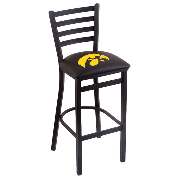 A black steel bar height chair with a padded black seat and ladder back with a yellow University of Iowa logo.