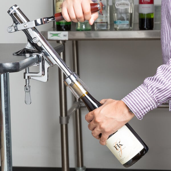A person using a Franmara Bar-Pull wine bottle opener to open a bottle of wine.