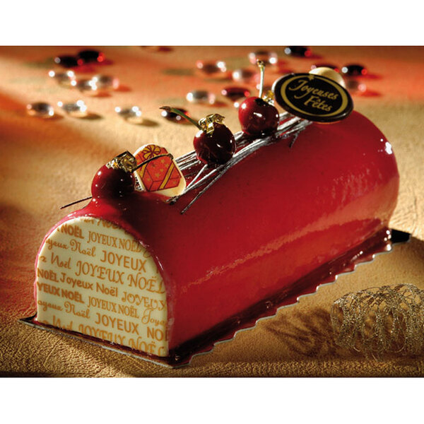 A red and white semicircle cake with cherries on top in a Matfer Bourgeat Buche cake mold.