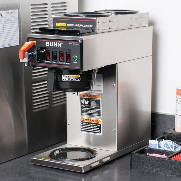 A Bunn commercial automatic coffee brewer with black and silver containers and a red handle.