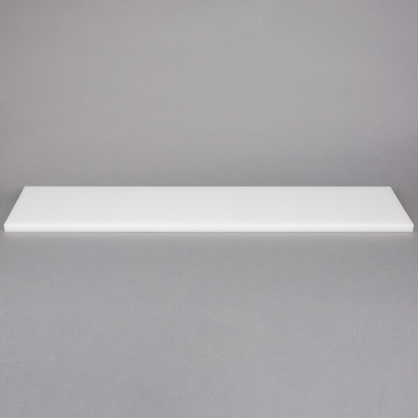 A white rectangular cutting board on a gray surface.