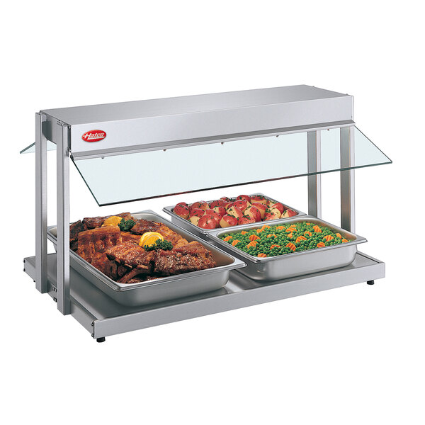 A Hatco countertop buffet warmer with three trays of food including meat, peas, and carrots.