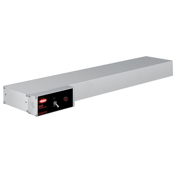A long rectangular metal shelf with an attached black box and red light.