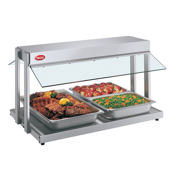 A Hatco countertop buffet warmer with three food trays containing meat and vegetables.