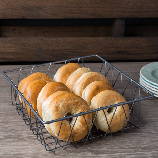 A Clipper Mill by GET gray powder coated square wire basket filled with bagels on a table.