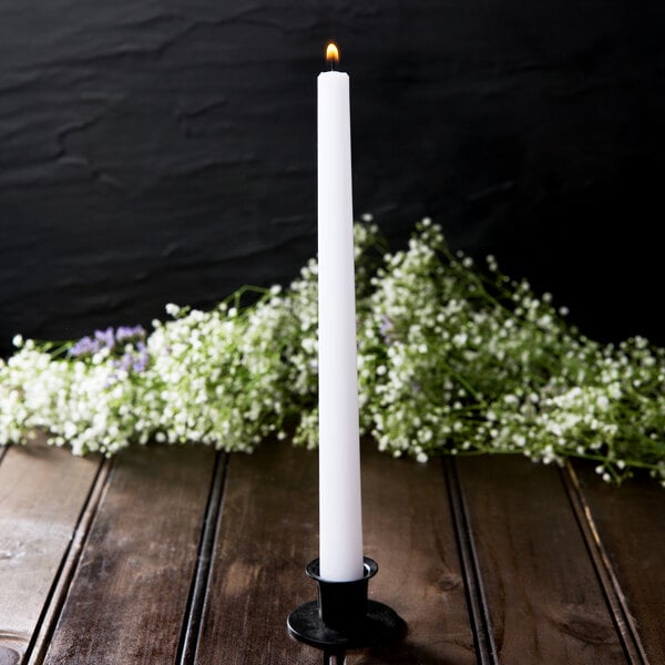 A Hyoola white taper candle on a table.