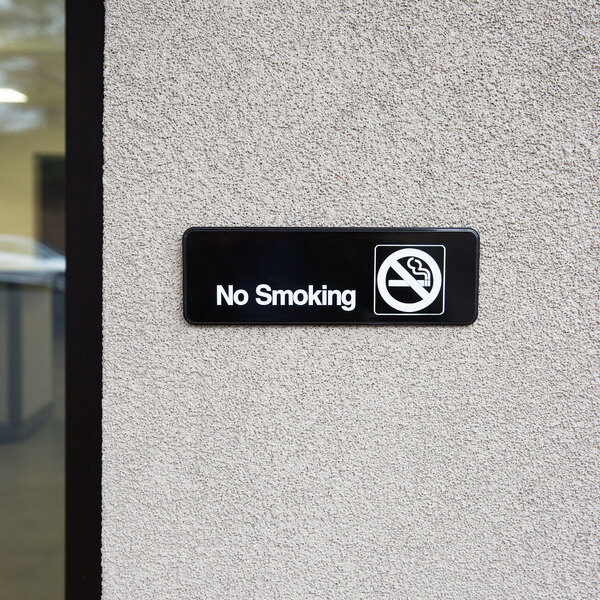 A black and white Traex No Smoking sign on a wall.