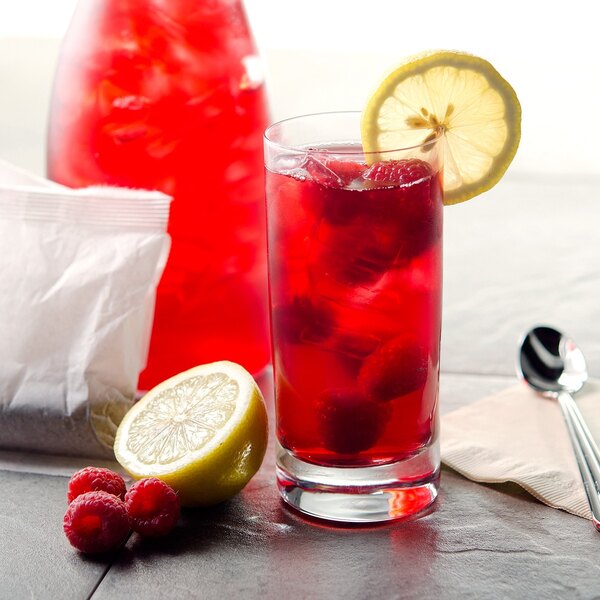 A glass of Bigelow red raspberry iced tea with lemon slices.