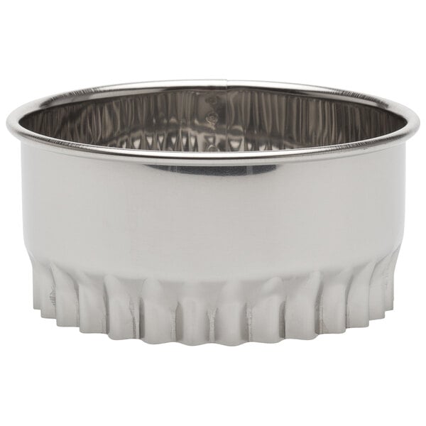 A silver stainless steel fluted round cutter with a ruffled edge.