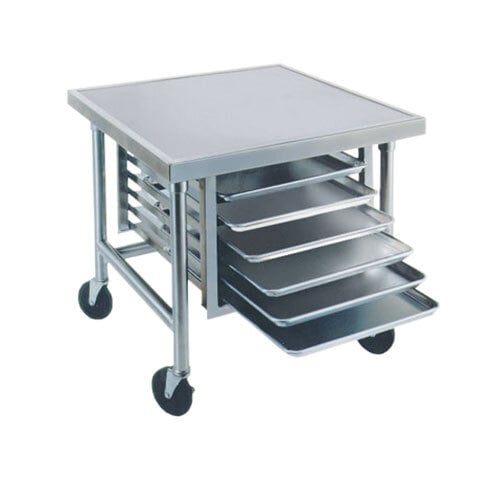 A white stainless steel mobile mixer table with tray slides holding trays.