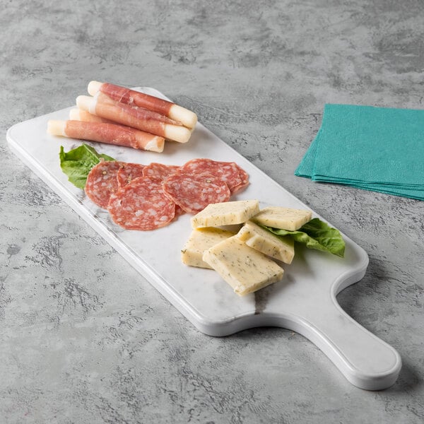 A white marble Thunder Group melamine serving board with meat and cheese on it.
