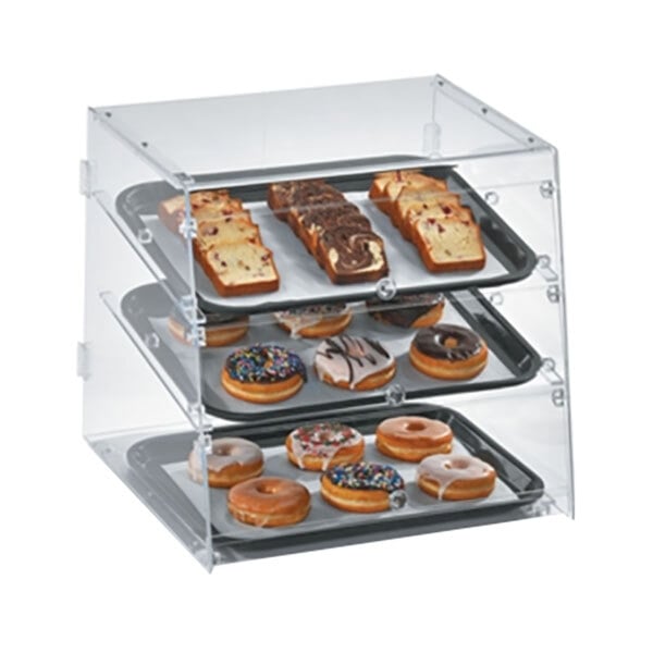 A Vollrath acrylic bakery display case on a counter with trays of donuts and pastries.