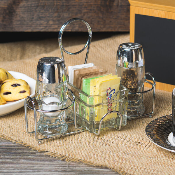 A Clipper Mill 2-compartment condiment caddy with salt and pepper shakers and cookies on a table.