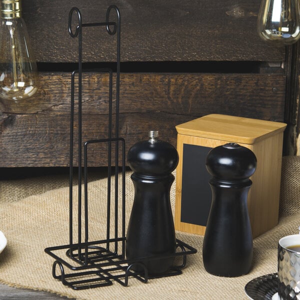A black Clipper Mill Teflon-coated table caddy with a menu holder holding salt and pepper shakers.