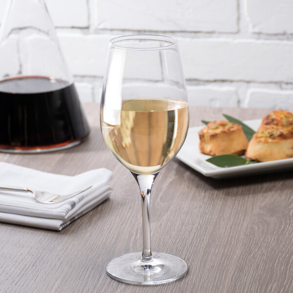 A Stolzle white wine glass full of white wine on a table