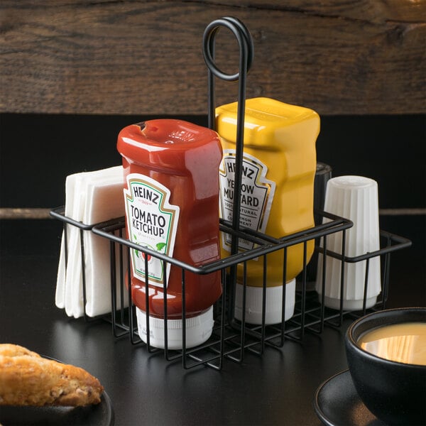 A black Clipper Mill by GET Teflon-coated iron 4-compartment condiment caddy on a hotel buffet table.