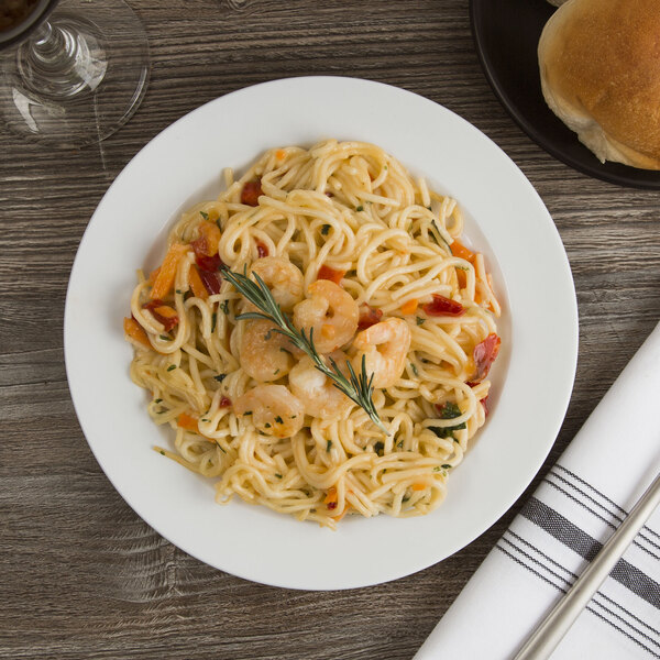 A Libbey medium rim porcelain plate with pasta, shrimp, and vegetables.