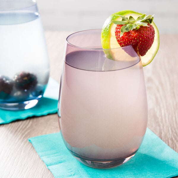 Two Stolzle Lilac stemless wine glasses filled with water, each garnished with a strawberry and lime slice.
