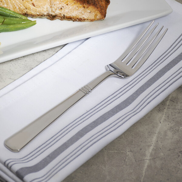 A Bon Chef stainless steel dinner fork on a plate with food.