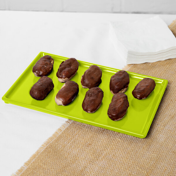 A chocolate covered pastry on a lime green Tablecraft metal tray.