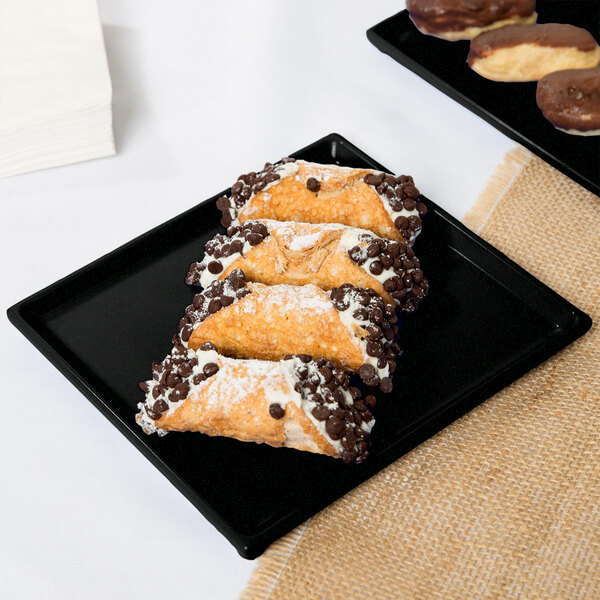 A Tablecraft black and green speckled cast aluminum rectangular cooling platter holding chocolate covered pastries.