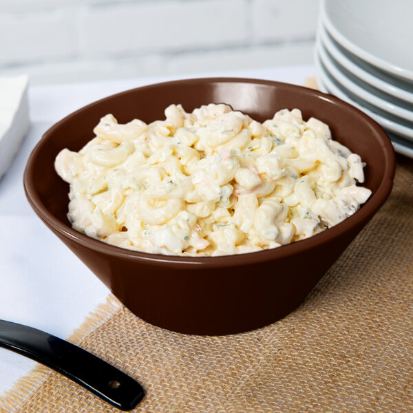 A brown Tablecraft cast aluminum bowl filled with macaroni salad.