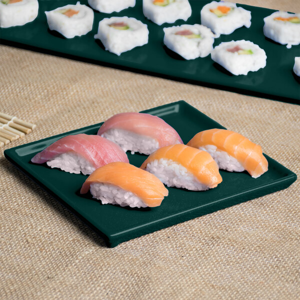 A Tablecraft hunter green and white speckle cast aluminum rectangular cooling platter with sushi on a table.
