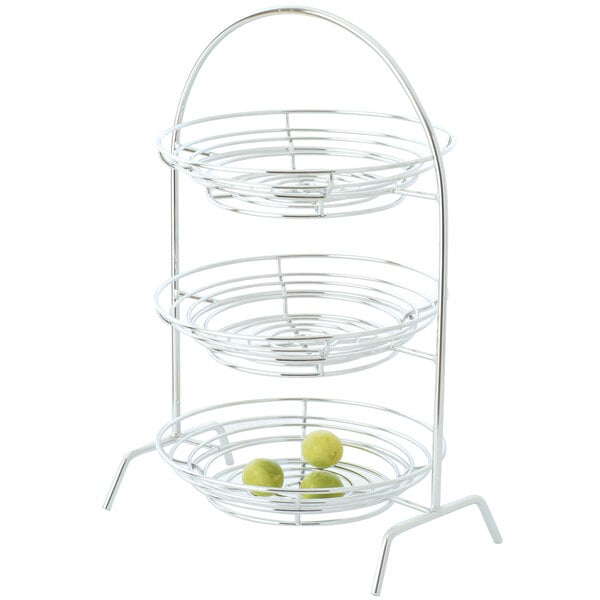 A 2-tier chrome plated iron riser with Clipper Mill by GET in a metal basket with fruit.