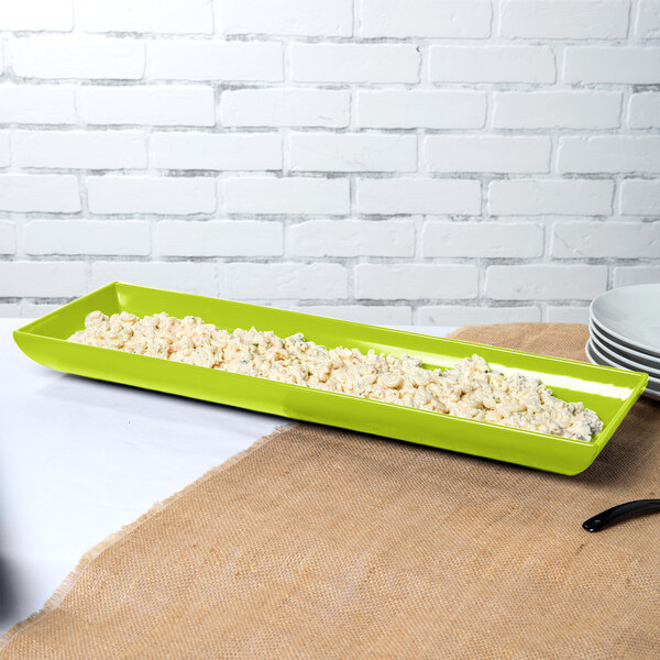 A lime green rectangular Tablecraft tray with food in it.