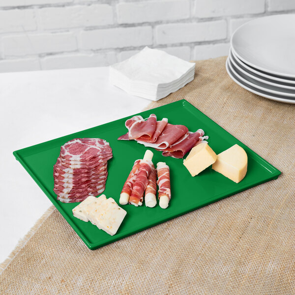 A green Tablecraft rectangular cast aluminum cooling platter with meat and cheese.