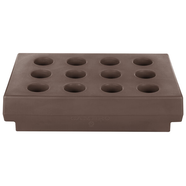 A dark brown rectangular cutlery rack with holes in it.