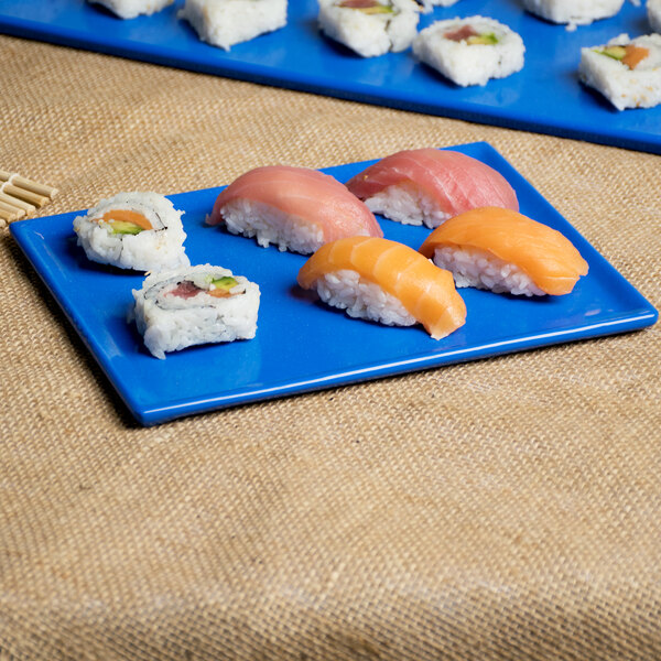 A blue Tablecraft cast aluminum rectangular cooling platter with sushi on it.