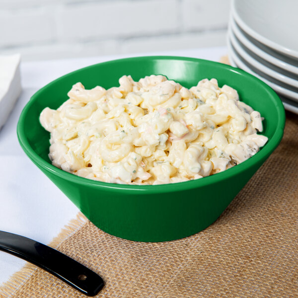 A green Tablecraft round cast aluminum bowl filled with macaroni salad.