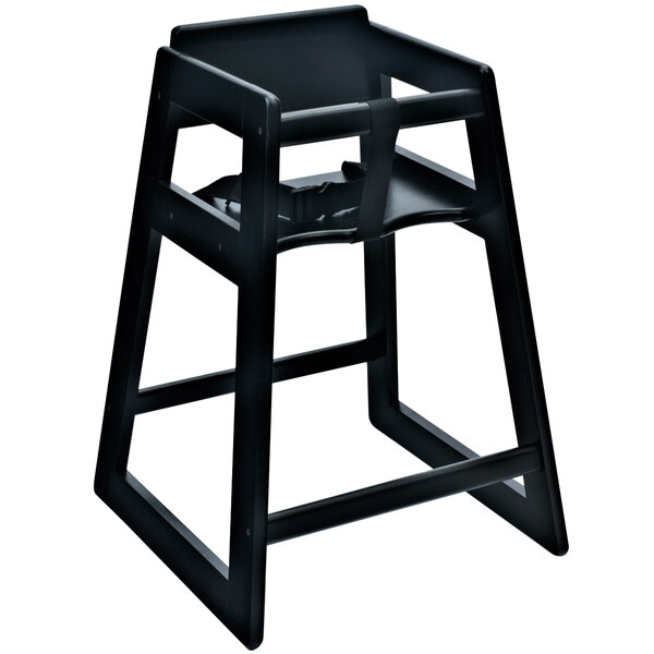 A Koala Kare black wood high chair with a strap on a wooden table.