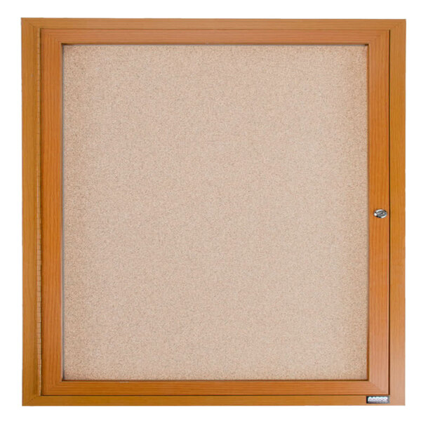 A wooden framed enclosed cork bulletin board with a key lock.