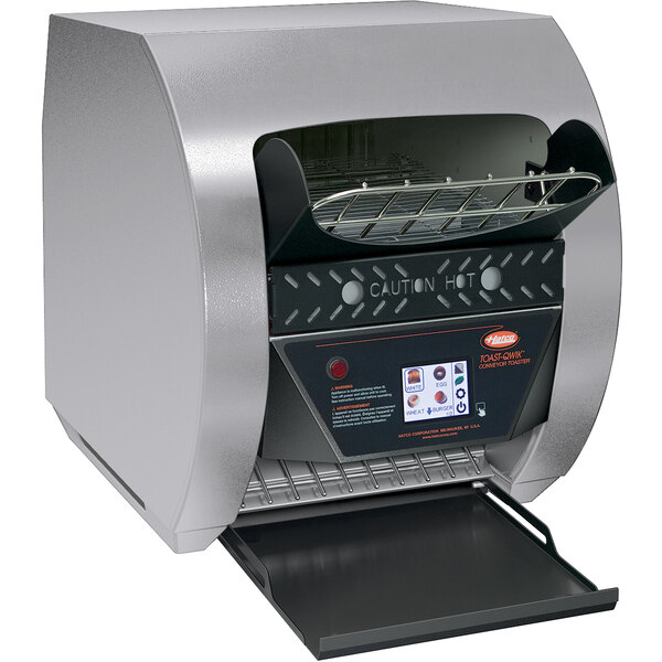A Hatco stainless steel conveyor toaster with digital controls on a counter in a deli.