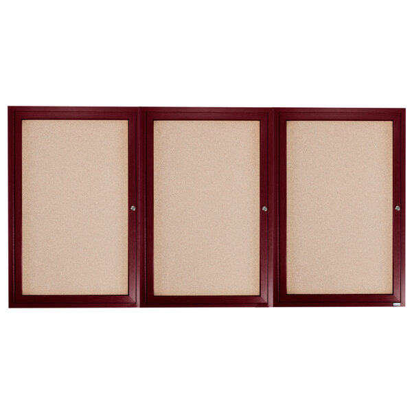Three wooden framed bulletin boards with three doors, each with a cork board inside.