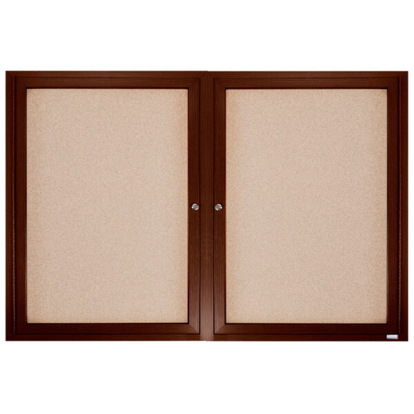 A brown framed enclosed bulletin board with cork and white boards inside.