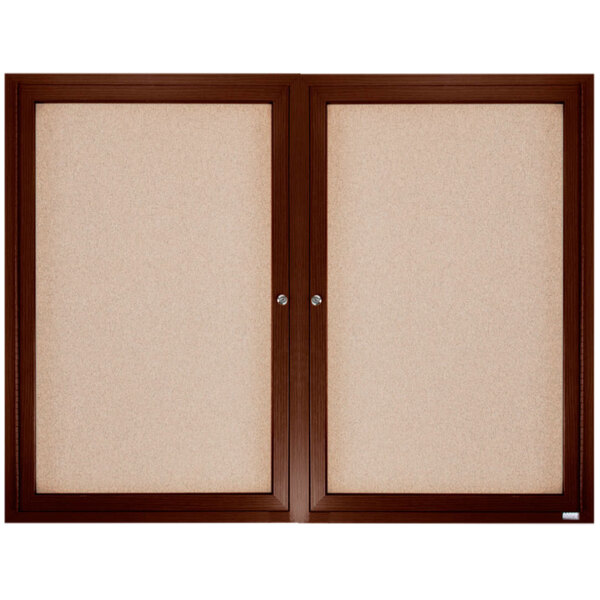 A white rectangular Aarco bulletin board with a brown wooden frame.