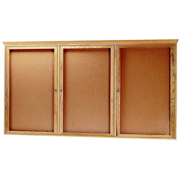 Three Aarco wooden enclosed bulletin boards with crown molding and doors.
