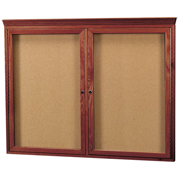 A wooden cherry framed enclosed bulletin board with cork.