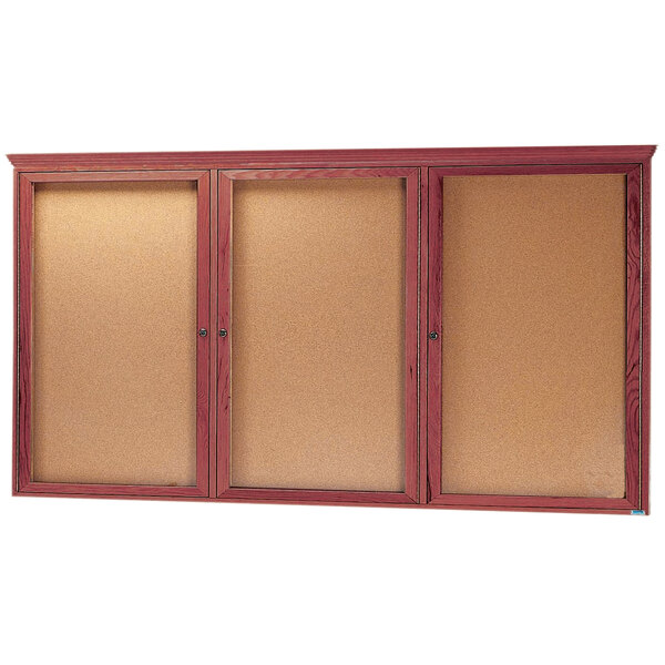 An Aarco cherry enclosed bulletin board with three glass doors.