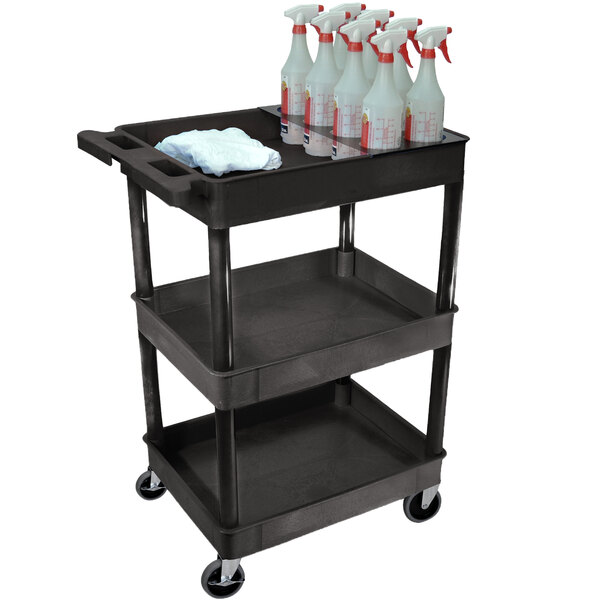 A black Luxor utility cart with three shelves holding spray bottles and a rag.