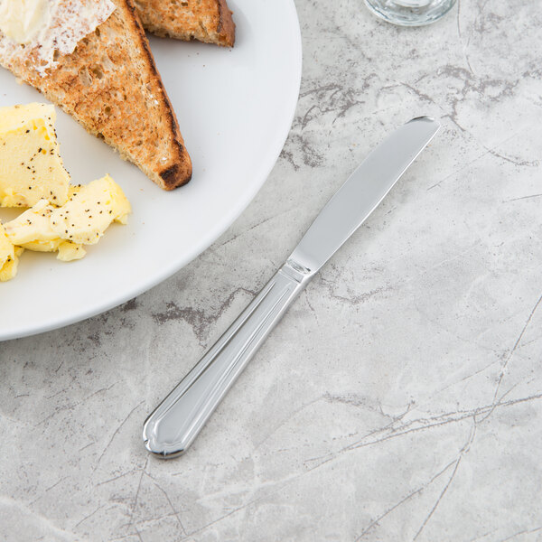 A Libbey Cortland bread and butter knife on a plate with toast and butter.