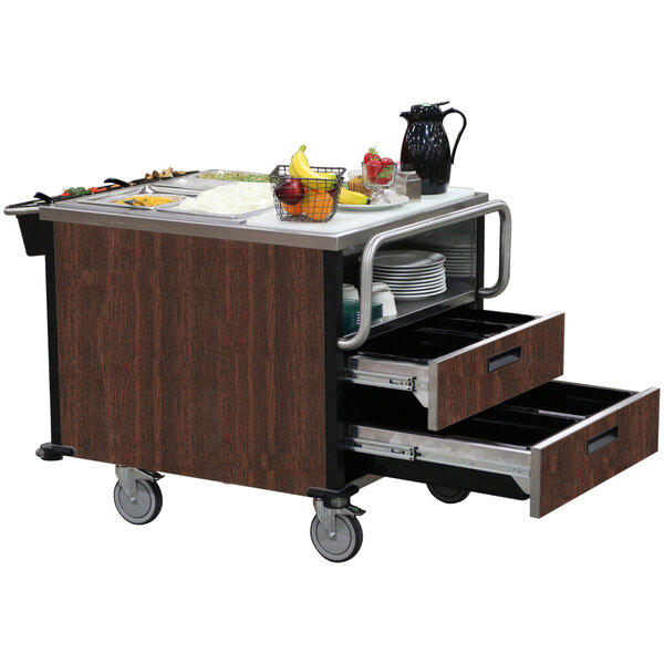 A Lakeside walnut dining room meal serving system with two heated wells on a wooden cart with a tray of food on it.