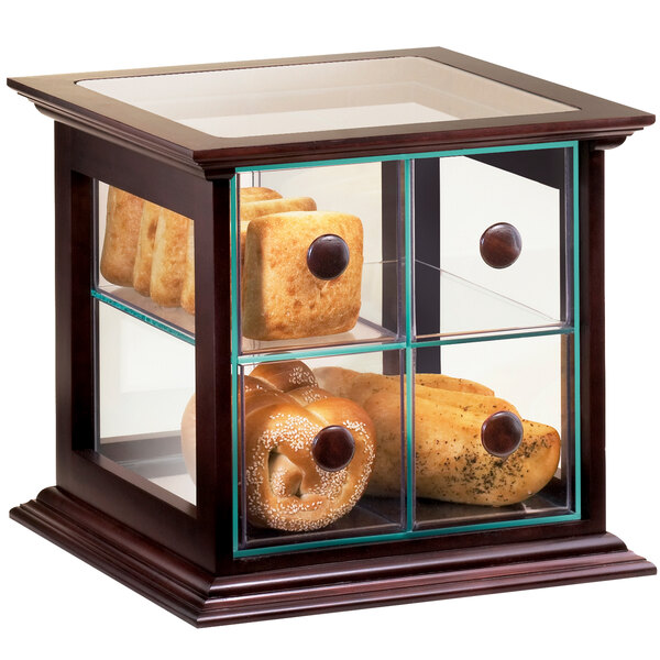 A Cal-Mil Westport wood frame bread box with drawers holding bread and rolls in a glass display case.