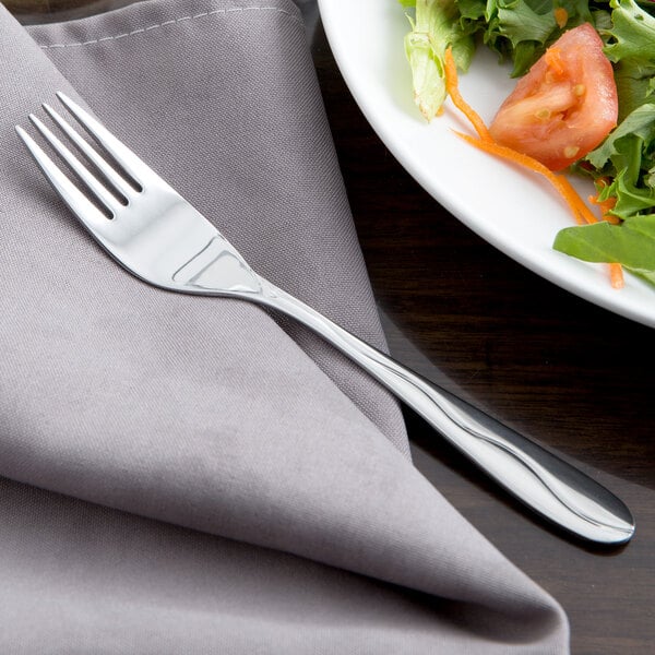 A Libbey stainless steel salad fork on a plate of salad.