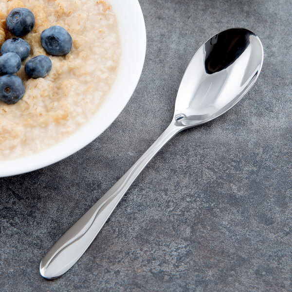 A bowl of oatmeal with blueberries and a Libbey stainless steel dessert spoon.